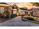 Elegant brick home with inviting exterior lights, manicured landscaping, and grand architectural details at 248 Montrose Dr, Mcdonough, GA 30253