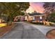 Beautiful brick home with a winding driveway and meticulously landscaped front yard, illuminated at dusk at 248 Montrose Dr, Mcdonough, GA 30253