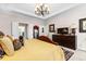 Bright main bedroom with chandelier, neutral walls, carpet, dark wood furnishings, and large windows at 248 Montrose Dr, Mcdonough, GA 30253