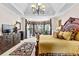 Spacious main bedroom with bay window, decorative curtains, chandelier, and dark wood furniture at 248 Montrose Dr, Mcdonough, GA 30253