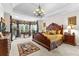 Spacious main bedroom with bay window, decorative curtains, chandelier, and dark wood furniture at 248 Montrose Dr, Mcdonough, GA 30253