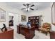 A well-lit office featuring a wooden desk, bookcase, comfortable chair, and ceiling fan at 248 Montrose Dr, Mcdonough, GA 30253