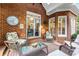 A covered outdoor patio with comfortable wicker furniture, brick accents, and sliding door access to the interior of the home at 248 Montrose Dr, Mcdonough, GA 30253