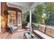 Comfortable covered brick patio with rocking chair, sofa and view of manicured backyard, perfect for relaxing and entertaining outdoors at 248 Montrose Dr, Mcdonough, GA 30253