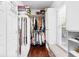 Organized walk-in closet featuring built-in shelves, a window seat, and hardwood floors at 248 Montrose Dr, Mcdonough, GA 30253