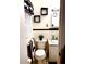 A compact bathroom featuring a toilet, small sink, and black and white decor at 5582 Brady Dr, Stone Mountain, GA 30087