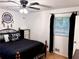 Bedroom featuring a comfortable bed, dark accents, and natural light through the window at 5582 Brady Dr, Stone Mountain, GA 30087