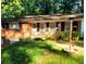 Inviting brick home featuring a landscaped front yard, complemented by lush greenery and a garden light at 5582 Brady Dr, Stone Mountain, GA 30087
