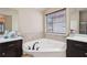 Elegant bathroom features dual sinks, dark wood vanities, and a soaking tub at 2126 Roberts View Trl, Buford, GA 30519