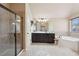 Elegant bathroom features a glass enclosed shower, dark wood vanity, and soaking tub at 2126 Roberts View Trl, Buford, GA 30519