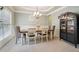 Elegant dining room with neutral walls, wainscoting, a chandelier, and a dark wood display cabinet at 2126 Roberts View Trl, Buford, GA 30519