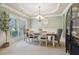 Elegant dining room with neutral walls, wainscoting, a chandelier, and a dark wood display cabinet at 2126 Roberts View Trl, Buford, GA 30519