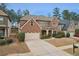 Beautiful brick home with an attached garage, complemented by a green lawn and landscaped bushes at 2126 Roberts View Trl, Buford, GA 30519