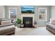 Cozy living area with a fireplace, two large windows, and comfortable seating at 2126 Roberts View Trl, Buford, GA 30519
