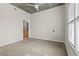 Spacious bedroom featuring neutral carpet, a ceiling fan, and an open doorway to an en-suite bathroom at 250 Pharr Ne Rd # 208, Atlanta, GA 30305