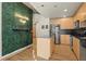 Modern kitchen featuring wood floors, stainless steel appliances, a stone-topped island, and a decorative wall feature at 250 Pharr Ne Rd # 208, Atlanta, GA 30305