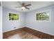 Bright bedroom with two windows, hardwood floors, ceiling fan, and soft blue walls at 2521 Whites Mill Ln, Decatur, GA 30032