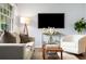 Inviting living room featuring a large-screen TV, stylish furnishings, and natural light creating an entertainment space at 2521 Whites Mill Ln, Decatur, GA 30032