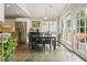 Sunny dining area featuring stone floors, a black table set, and access to the outdoors at 3734 Powers Ferry Nw Rd, Atlanta, GA 30342