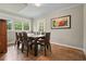 The dining room features a wooden table with seating for eight and natural light streaming through the windows at 3734 Powers Ferry Nw Rd, Atlanta, GA 30342