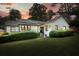 Charming painted brick home with black trim, dark roof, landscaped yard, and solar panels at 3734 Powers Ferry Nw Rd, Atlanta, GA 30342