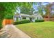 Landscaped front yard with white painted brick home, dark trim and solar panels on the roof at 3734 Powers Ferry Nw Rd, Atlanta, GA 30342