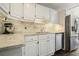 Well-lit kitchen with white cabinets, granite countertops, and stainless steel appliances at 3734 Powers Ferry Nw Rd, Atlanta, GA 30342