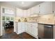 Charming kitchen featuring white cabinets, stainless steel appliances, and access to the dining area at 3734 Powers Ferry Nw Rd, Atlanta, GA 30342