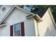 Image shows the home's siding and trim with its red shutters and window at 5415 Twin Lakes Dr, Atlanta, GA 30349