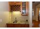 Dry bar area with granite counters, tile backsplash, and wine storage at 6529 Terraglen Way, Locust Grove, GA 30248