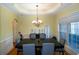 Formal dining room with hardwood floors, wainscoting, and a modern chandelier at 6529 Terraglen Way, Locust Grove, GA 30248