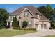 Beautiful home with stone and brick exterior, well-manicured lawn, and attached two-car garage at 6529 Terraglen Way, Locust Grove, GA 30248