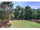 Wide backyard with a wooden fence and many green trees in background at 1124 Monarda Nw Way, Acworth, GA 30102