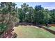 Spacious fenced backyard with lush lawn and mature trees provides privacy at 1124 Monarda Nw Way, Acworth, GA 30102