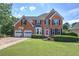 Charming brick home boasts a well-manicured lawn, attached two-car garage, and a welcoming front entrance at 1124 Monarda Nw Way, Acworth, GA 30102