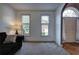 Inviting living room with plush carpet, natural light, and traditional front door at 1124 Monarda Nw Way, Acworth, GA 30102