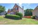 Brick home with green yard, featuring a spacious lawn and privacy landscaping at 1124 Monarda Nw Way, Acworth, GA 30102