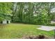 Large grass-covered backyard with a storage shed surrounded by many trees at 2358 Dabney Ter, East Point, GA 30344