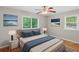 Bright bedroom features a ceiling fan, hardwood floors, two windows and beach-themed wall art at 2358 Dabney Ter, East Point, GA 30344