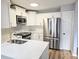 Renovated kitchen with stainless steel appliances, bright white cabinets, and quartz countertops at 5025 Highland Club Dr, Marietta, GA 30068