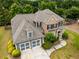 Aerial shot of a two-story home with a brick facade, well-maintained lawn, and attached two-car garage at 1045 Fords Crossing Nw Dr, Acworth, GA 30101