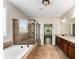 Bathroom featuring a soaking tub, a glass shower, double sinks, and granite countertops at 1045 Fords Crossing Nw Dr, Acworth, GA 30101