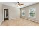 Bright bedroom featuring carpet flooring, ceiling fan, and windows offering natural light and views at 1045 Fords Crossing Nw Dr, Acworth, GA 30101