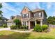 Charming two-story brick home featuring black shutters, manicured lawn, and lush landscaping under a sunny sky at 1045 Fords Crossing Nw Dr, Acworth, GA 30101