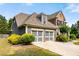 Two-story home with a two-car garage, brick accents, and a well-maintained lawn at 1045 Fords Crossing Nw Dr, Acworth, GA 30101