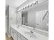 Well-lit bathroom with dual sinks, large mirror, and classic white cabinets at 1685 Great Oaks Dr, Lawrenceville, GA 30045
