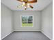 Bright bedroom with a window overlooking a green yard and modern ceiling fan at 1685 Great Oaks Dr, Lawrenceville, GA 30045