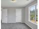 This bedroom features neutral paint, gray carpet, a double door closet and large window at 1685 Great Oaks Dr, Lawrenceville, GA 30045