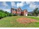 Charming red brick home with a manicured lawn, two-car garage, and classic black shutters at 1685 Great Oaks Dr, Lawrenceville, GA 30045