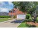Charming red brick home with manicured lawn, two-car garage, and mature landscaping at 1685 Great Oaks Dr, Lawrenceville, GA 30045